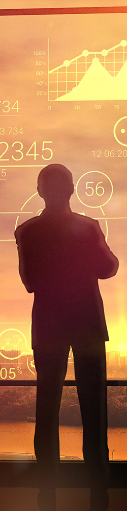 Silhouette of a man in a huge office in front of large windows 